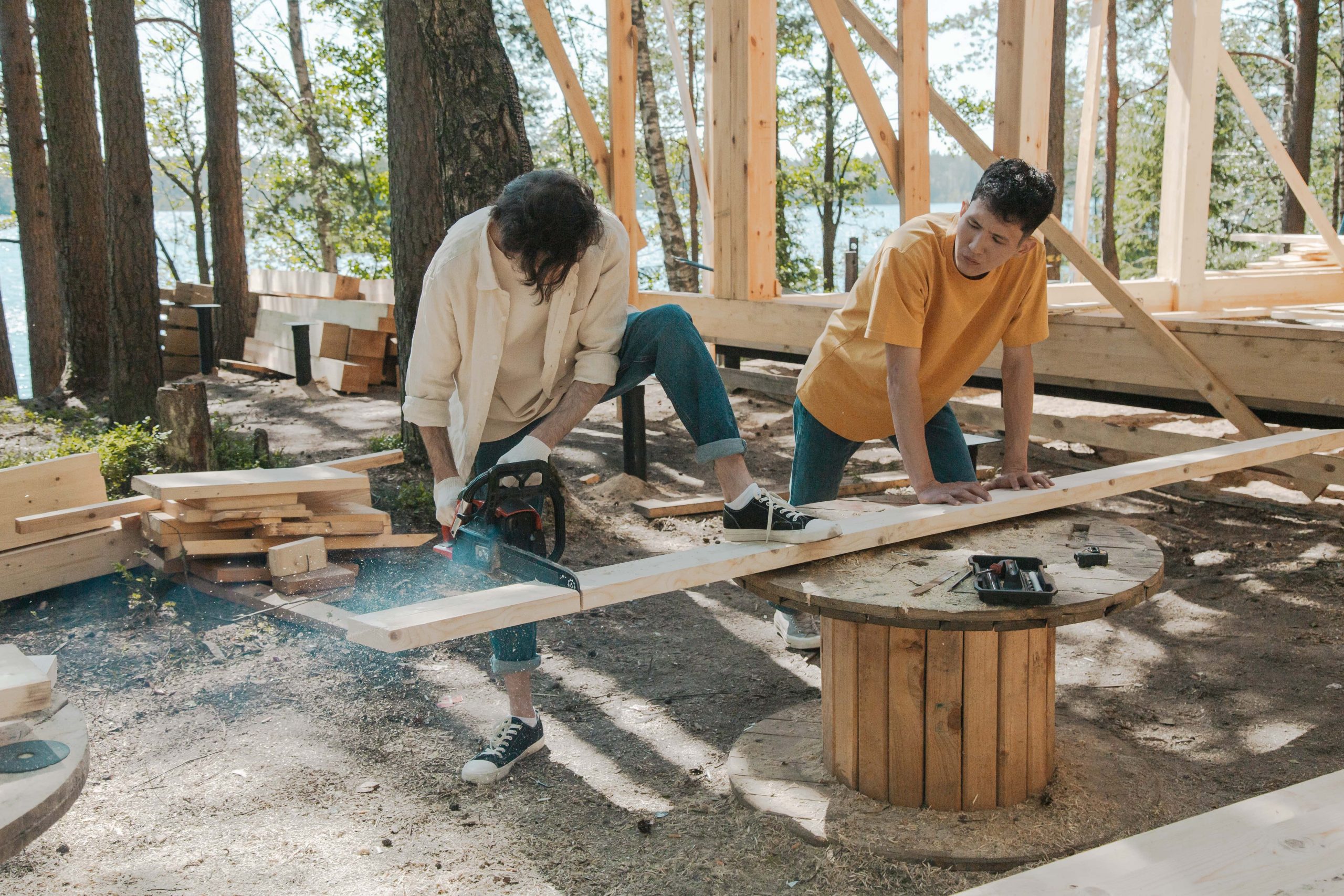 2 men cutting 2x4 building a house